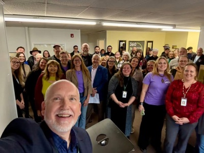 Men and women celebrating the ribbon cutting for the 360 Access Hub in Oakland MD.